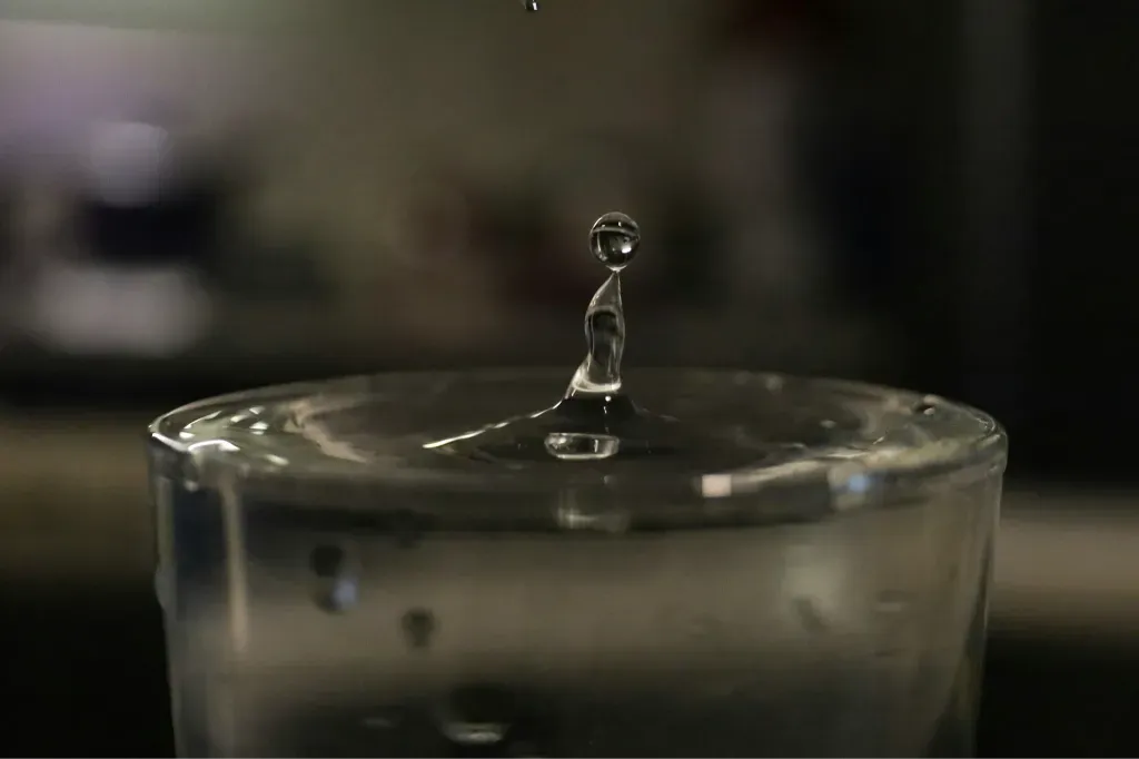 a drop of water falling into a glass of water